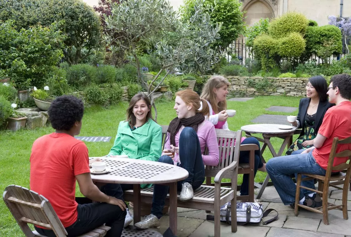 Students having tea in the Vaults and Gardens cafe with All Souls College in the background